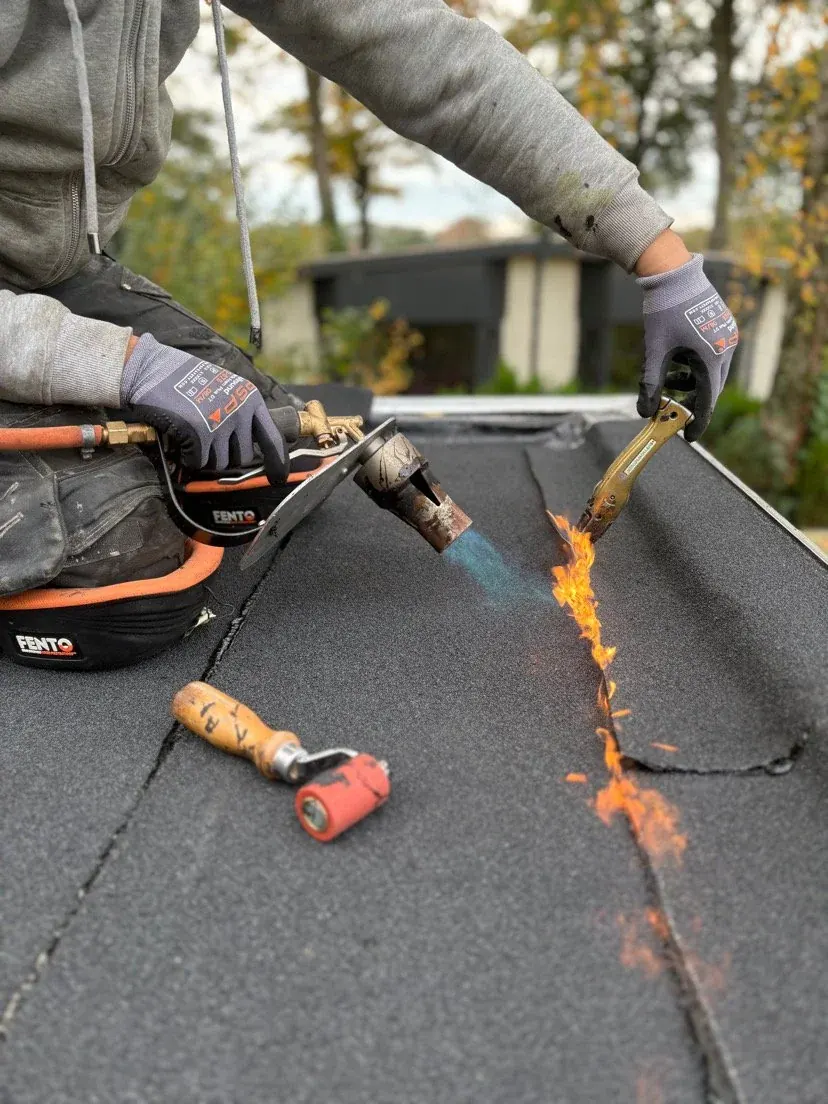 Dakdekker brandt bitumen dakbedekking aan voor waterdichte afwerking — dakdekker Zeist