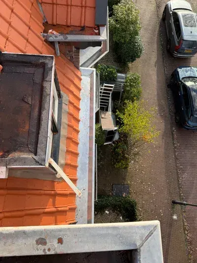 Dakrenovatie met nieuwe pannen en zinken goot in Haarlem